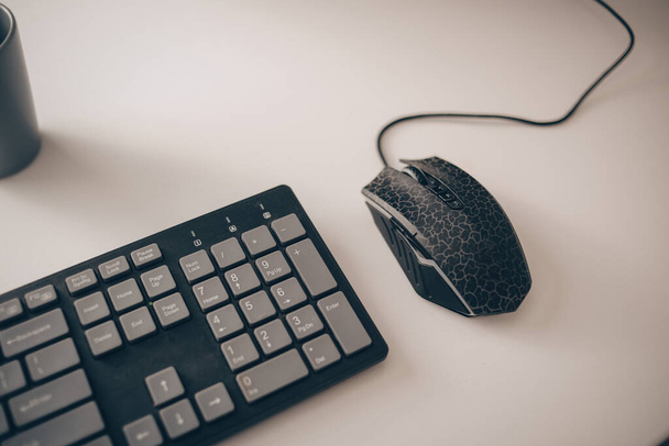 The English keyboard is on a white table and a mouse. - Photo, Image