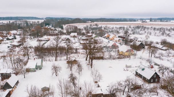 Akniste, Jekabpils, Latvia, Baltics.Beautiful panoramic aerial view photo from flying drone to Akniste city in winter.Beautiful winter view with snowy snow on small town fields and forests. (series) - Photo, Image