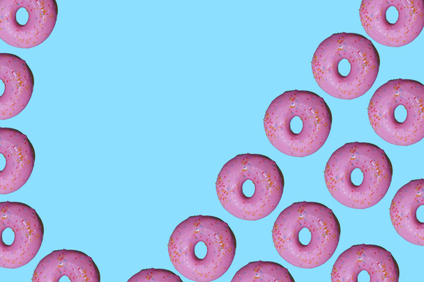Donut pattern lay flat on top view blue background. - Foto, afbeelding