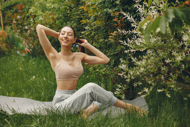 Woman practicing advanced yoga in a park - Foto, immagini