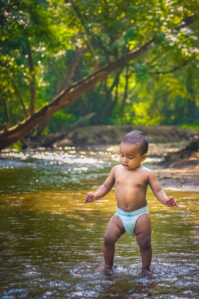 Pequeño niño lindo jugando en el agua del río. Retrato de niño divirtiéndose y disfrutando en un río del bosque. Pequeño chico divertido jugando en el agua. Stock de imágenes de Baby Boy. - Foto, Imagen
