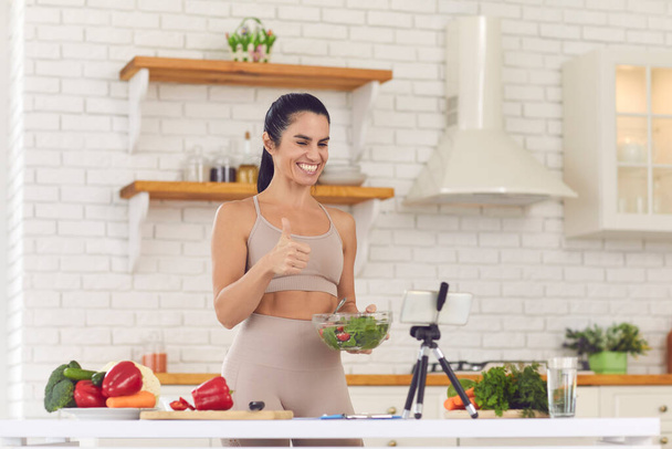 Smiling fit vlogger filming culinary video blog, giving dieting advice and sharing salad recipe - Zdjęcie, obraz
