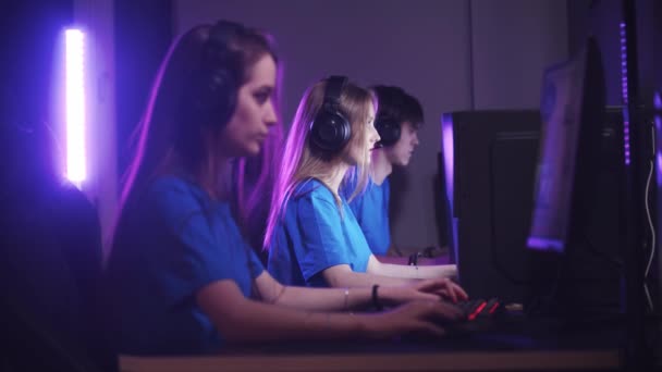 Skupina přátel, kteří sedí v herním klubu a mají online herní turnaj - otáčejí hlavy ke kameře - Záběry, video