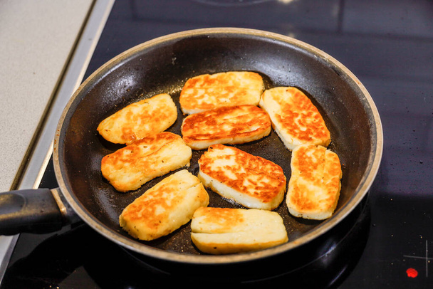 Halloumi cheese frying in a pan with olive oil. - Photo, Image