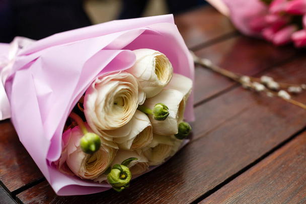 Букети з білих і рожевих тюльпанів. Два квіткових букети лежать на дерев'яному столі. Основна ідея для вітальної листівки. Весняний час
 - Фото, зображення