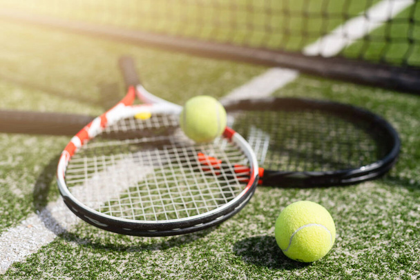 新しく塗装されたテニスコートのテニスラケットと新しいテニスボール - 写真・画像