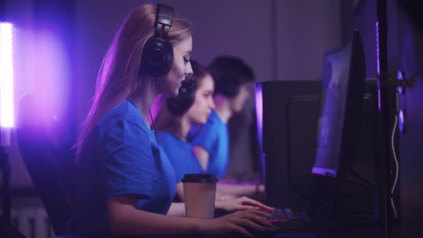 vriendengroep die in de gameclub zit en een online gamingtoernooi heeft - vrouw die koffie drinkt op de voorgrond - Video