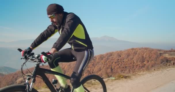 Idősebb férfi biciklizik a hegyekben nappal - Felvétel, videó