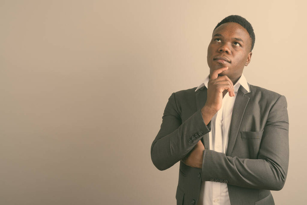 Joven hombre de negocios africano usando traje contra fondo blanco - Foto, imagen