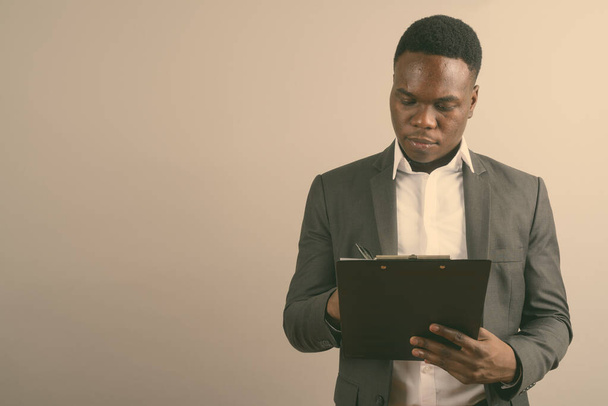 Junger afrikanischer Geschäftsmann trägt Anzug vor weißem Hintergrund - Foto, Bild