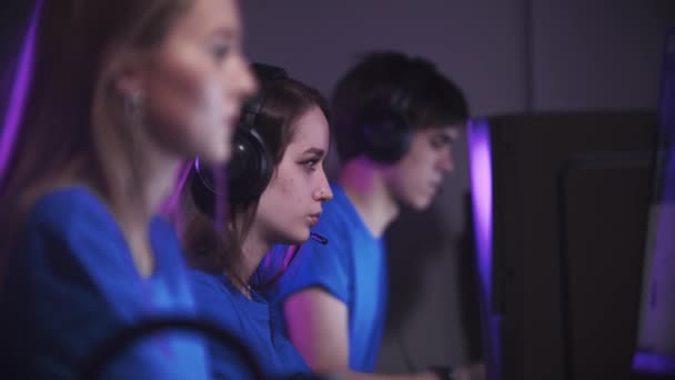 Groupe d'un homme et deux femmes assis dans le club de jeu et ayant un tournoi de jeu en ligne - Séquence, vidéo