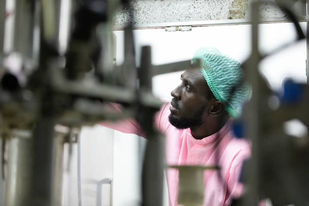 Afryki mężczyzna fabryka pracownik patrząc stary maszyna w fabryce  - Zdjęcie, obraz
