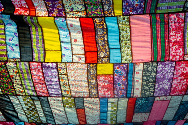 Un enorme tessuto artistico colorato, realizzato da una combinazione di pezzi colorati di abiti inutilizzati e raccolti da un sarto. - Foto, immagini