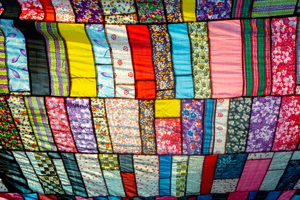 A huge colorful artistic fabric, made from a combination of colorful pieces of unused and collected clothes by a tailor. - Photo, Image