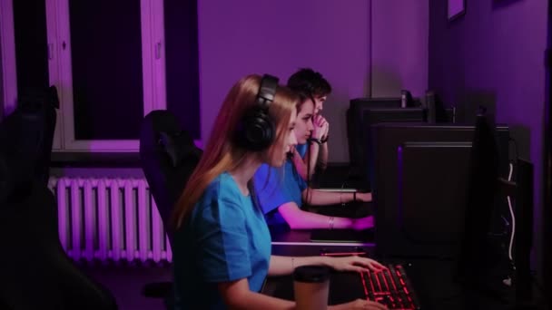 Online gaming - three friends sitting in the gaming club and having an online gaming tournament - winning the round and cheers up - Footage, Video