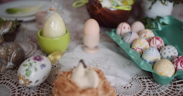 Huevos de Pascua en extrusora en mesa decorada - Imágenes, Vídeo