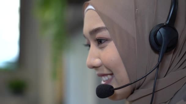 Müslüman çağrı merkezi personeli. Genç çağrı merkezi müşteri sorularını cevaplamaya çalışıyor. Ofiste çalışan genç bayan müşteri destek yöneticisi. - Video, Çekim