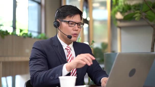 Het jonge call center werkt aan het beantwoorden van klantvragen. Jonge mannelijke customer support executive werken in kantoor. - Video