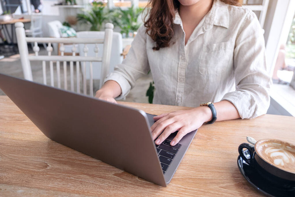 Крупним планом зображення жінки, яка використовує і друкує на клавіатурі ноутбука на столі
 - Фото, зображення