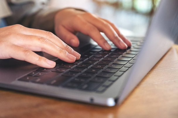 Imagem de close-up de mãos usando e digitando no teclado do laptop na mesa - Foto, Imagem