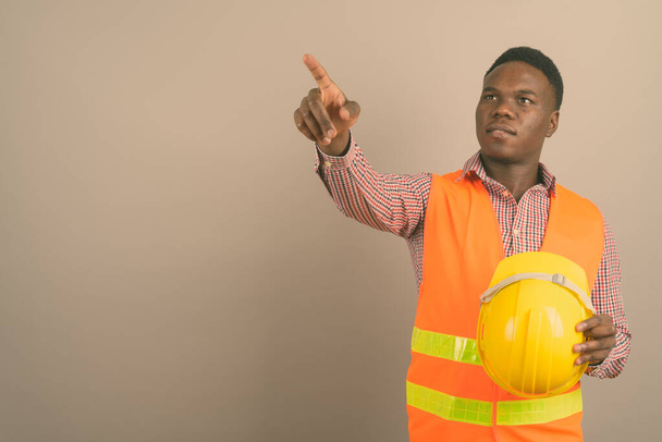 Young African man construction worker against white background - Fotografie, Obrázek