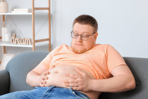 Stressed overweight man at home. Weight loss concept - Photo, Image