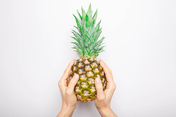 Kypsä ananas naisen kädessä eristetty valkoisella pohjalla.  - Valokuva, kuva