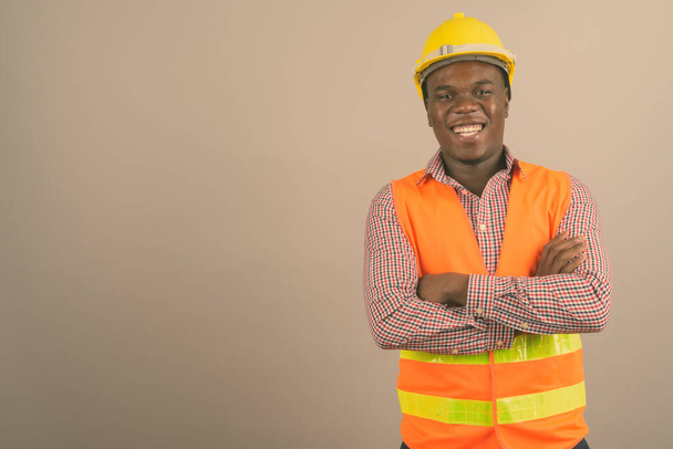 Fiatal afrikai férfi építőmunkás fehér háttér - Fotó, kép