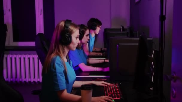 Gry online - trzech przyjaciół przegrywających grę w klubie komputerowym - zdejmuje słuchawki i rozmawia - Materiał filmowy, wideo