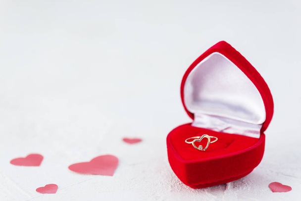 Ring in the form of a heart in a box on a background of red hearts. Valentine's Day. - Foto, immagini