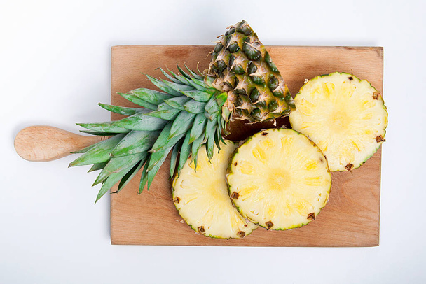  Ripe pineapple isolated on wooden background.  - Foto, immagini
