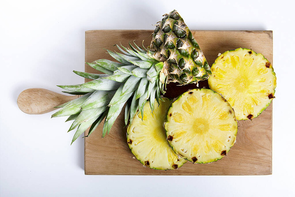  Rijp ananas geïsoleerd op houten achtergrond.  - Foto, afbeelding