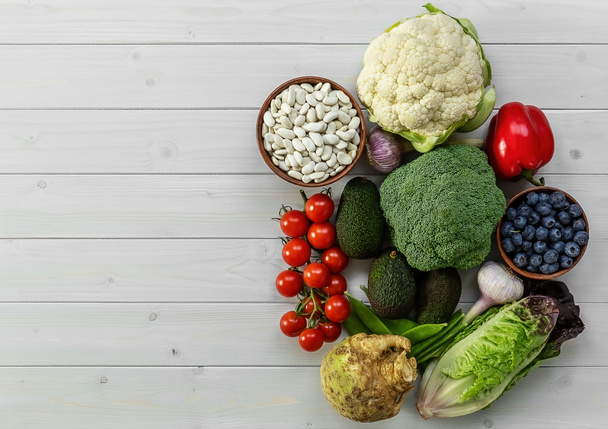 Zdravé potraviny pozadí, trendy rostlinné dietní produkty - čerstvá syrová zelenina, ovoce a fazole. přírodní dřevěný povrch. - Fotografie, Obrázek