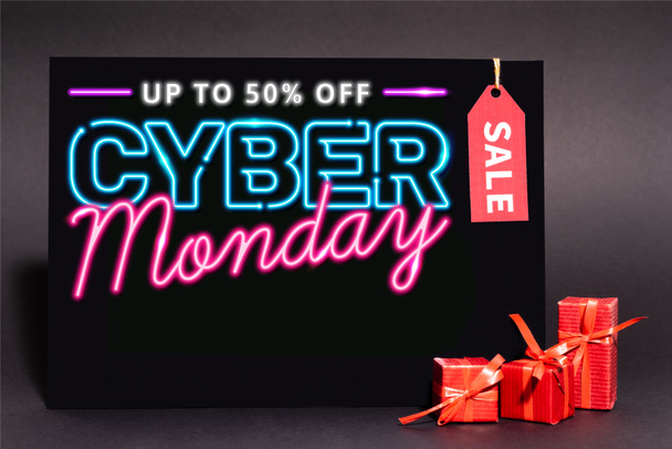pancarte avec jusqu'à 50 pour cent de réduction, cyber lundi lettrage et étiquette de vente près de cadeaux sur fond sombre - Photo, image