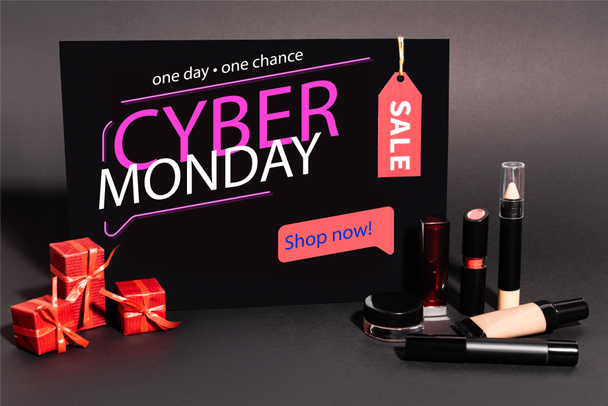 plakkaat met een dag, een kans, cyber maandag belettering en geschenken in de buurt van decoratieve cosmetica op donkere achtergrond - Foto, afbeelding