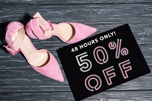 Ansicht von rosa Schuhen in der Nähe von Plakaten mit nur 48 Stunden, 50 Prozent Rabatt auf Schriftzüge auf Holzoberfläche - Foto, Bild