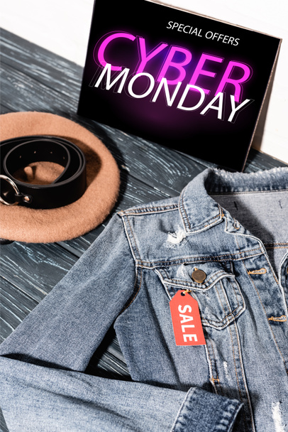 giacca di denim blu vicino al cartello con offerte speciali, lettering cyber lunedì, berretto e cintura - Foto, immagini