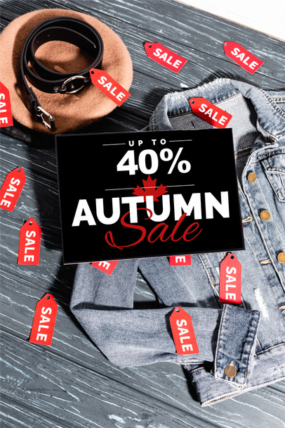 niebieska kurtka jeansowa w pobliżu beretu, pasek i tabliczka z 40% zniżką, jesienny napis sprzedaży na drewnianej powierzchni - Zdjęcie, obraz