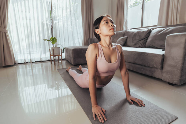 Young woman stretching after exercise at home. Fit woman workout at home. Home exercise. - Photo, Image