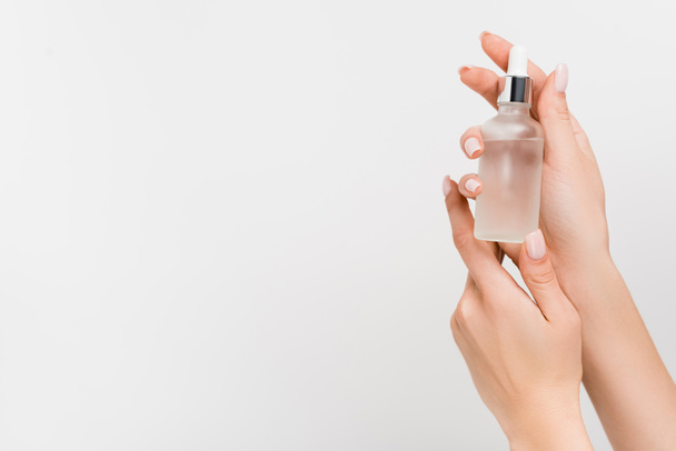 cropped view of woman holding bottle with serum in hands isolated on white - Φωτογραφία, εικόνα