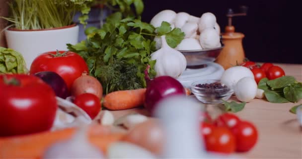 Lähikuva Erilaisia vihanneksia pöydällä pyörivä. Tuore tomaatti, porkkana, punainen sipuli ja valkosipuli. - Materiaali, video