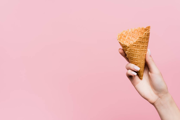 cropped view of woman holding waffle cone isolated on pink - Foto, imagen