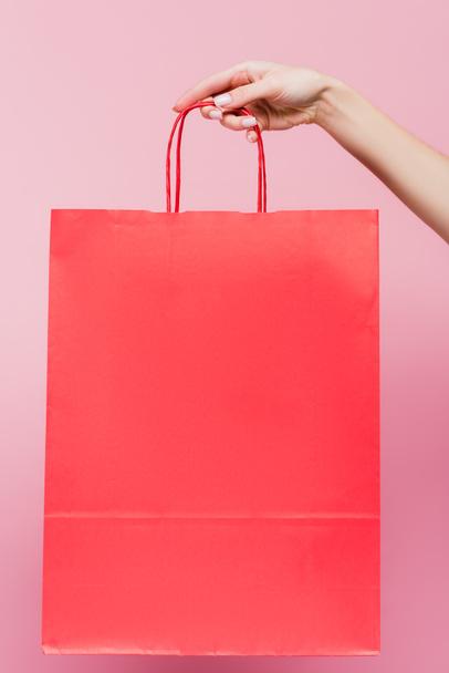 vista cortada de mulher segurando saco de compras isolado em rosa - Foto, Imagem