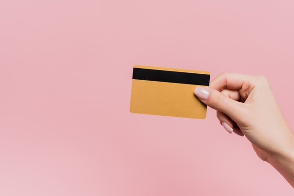 vista parcial de la mujer en posesión de la tarjeta de crédito en la mano aislado en rosa - Foto, Imagen