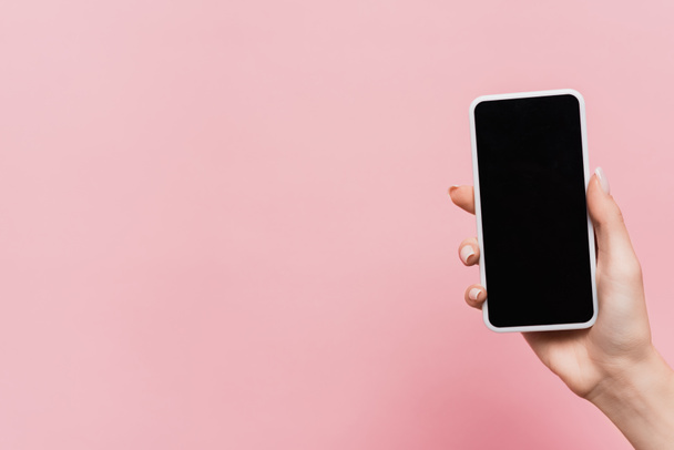 cropped view of woman holding smartphone with blank screen in hand isolated on pink - Photo, Image