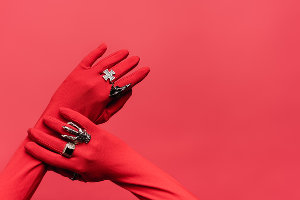 vista ritagliata delle mani femminili in guanti con anelli isolati su rosso - Foto, immagini