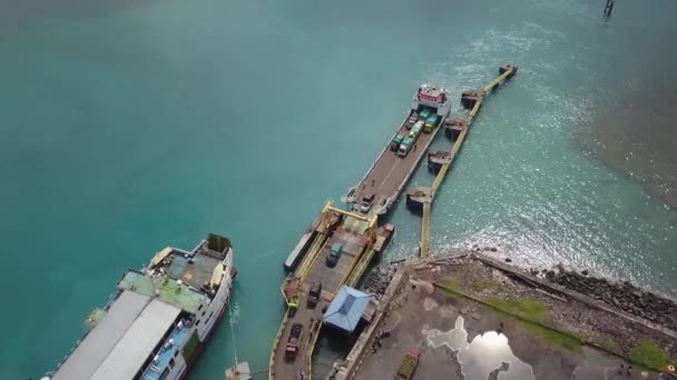 Magas kilátás a komp hajó szállítás sok autó és áru eléri a kikötőt, a hajó, hogy öböl a szigeten. 4K Aeriel nézet - Felvétel, videó