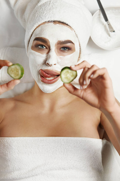 Beautiful Woman with clay facial mask in beauty spa. Skin care. Beauty Concept. Facial treatment. Cosmetology.  - Valokuva, kuva