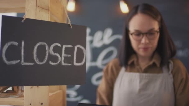 Close-up van de jonge Aziatische koffie verkoper draaien open bord opening cafetaria voor klanten - Video