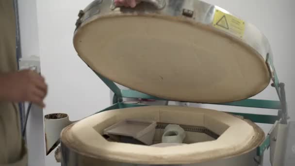 Töpferin legt Keramik in Ofen. - Filmmaterial, Video